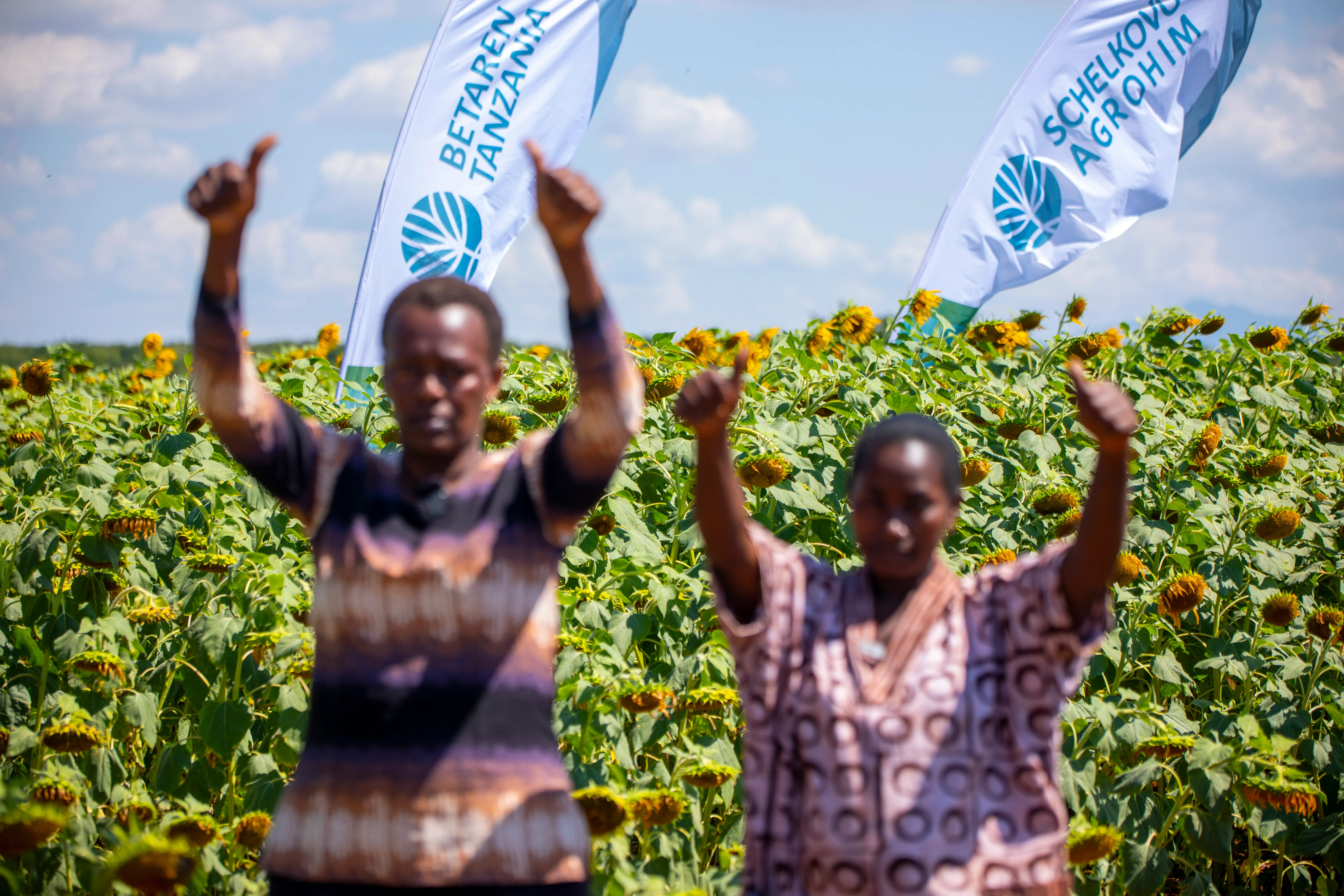 Visitors giving a thumbs up beside Betaren field flags